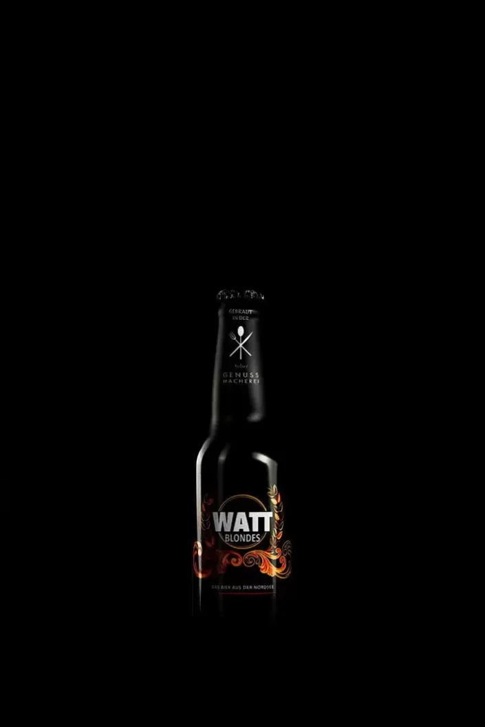 Eine edle Flasche Watt Blondes Bier vor schwarzem Hintergrund, kunstvoll in Szene gesetzt für die Produktfotografie auf Sylt.