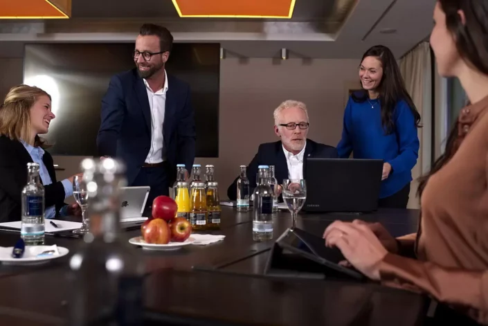 Professionelle Business-Portraits bei einer Konferenz auf Sylt: Ein Team diskutiert in entspannter Atmosphäre an einem modernen Konferenztisch.