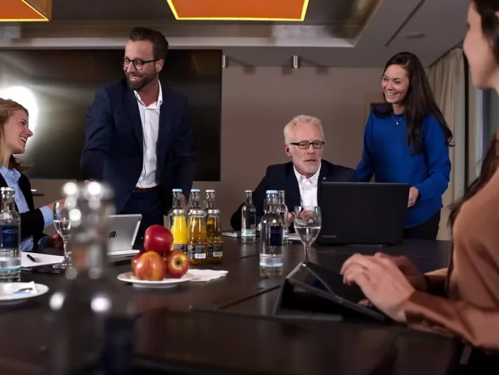 Professionelle Business-Portraits bei einer Konferenz auf Sylt: Ein Team diskutiert in entspannter Atmosphäre an einem modernen Konferenztisch.