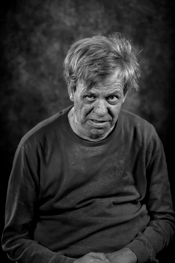 Schwarz-Weiß-Portrait eines Mannes mit zerzaustem Haar und nachdenklichem Blick, aufgenommen in einem professionellen Studio-Setting auf Sylt.