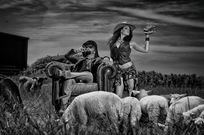 Ein bauerpaar auf Sylt posiert auf einem englischem Sessel in Landschaft von Sylt