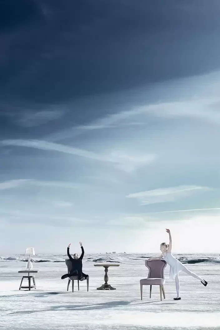 Künstlerisches Portrait: Eine Ballerina und eine Person auf Stühlen in einer weiten, winterlichen Insellandschaft – elegante Fotografie.