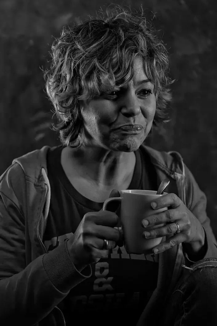 Schwarz-Weiß-Portrait einer Frau mit Tasse, das die künstlerische Qualität unserer Portraits auf Sylt, Amrum und Föhr eindrucksvoll unterstreicht.
