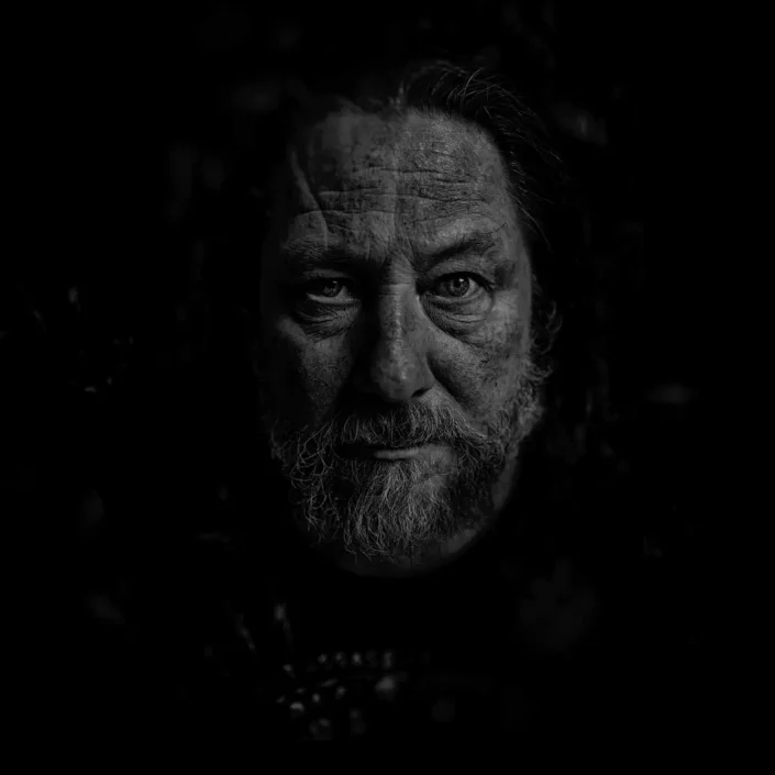 Eindrucksvolles, künstlerisches Portrait eines Mannes mit Bart in Schwarz-Weiß, das Tiefe und Charakter in der Portraitfotografie zeigt. Der man ist Der Sänger Oliver Strempler.
